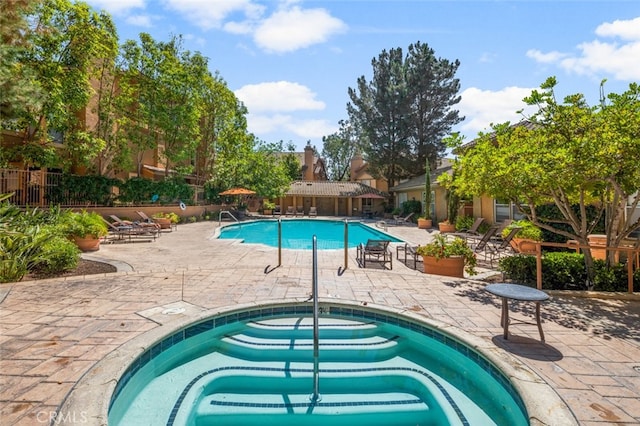 view of swimming pool with a community hot tub and a patio area