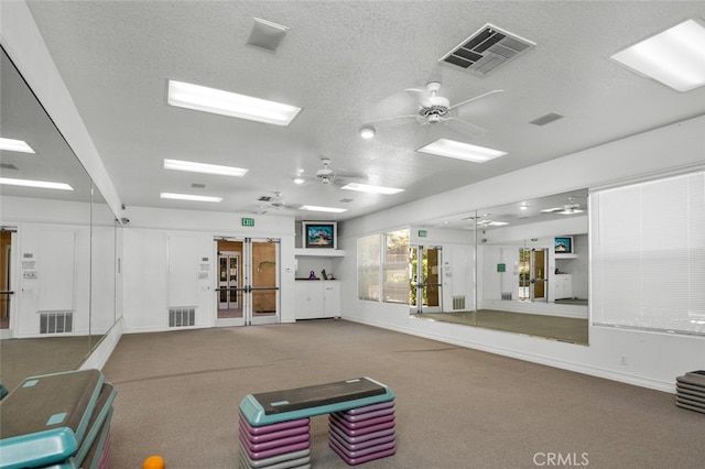 interior space with a textured ceiling, carpet, and ceiling fan