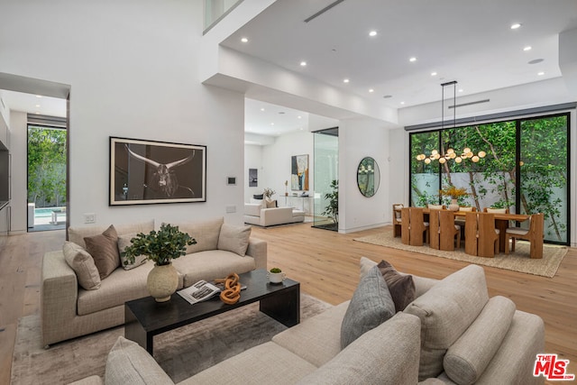 living room featuring light wood-type flooring and a notable chandelier