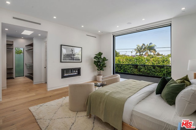 bedroom with light hardwood / wood-style floors and multiple windows