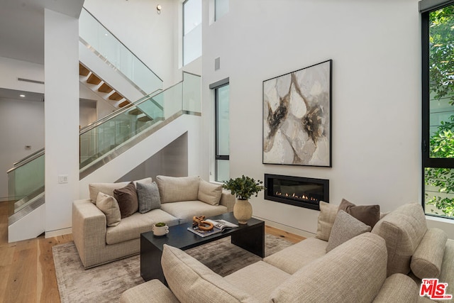 living room with light hardwood / wood-style floors and a high ceiling