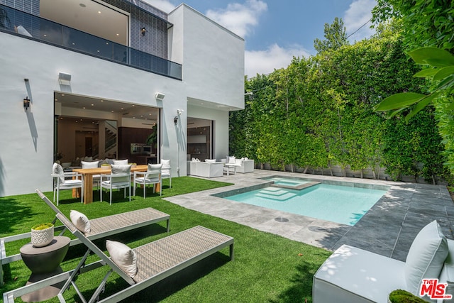 view of pool with an outdoor living space, a patio area, a yard, and an in ground hot tub