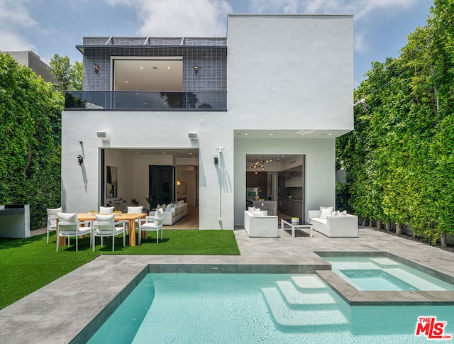 rear view of property with outdoor lounge area, solar panels, a swimming pool with hot tub, a balcony, and a patio