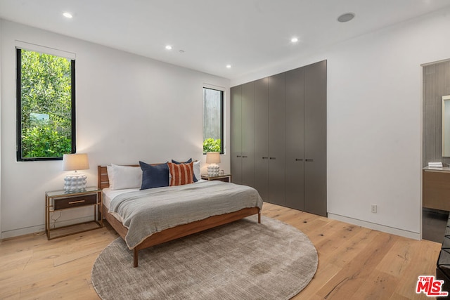 bedroom featuring light wood-type flooring and connected bathroom