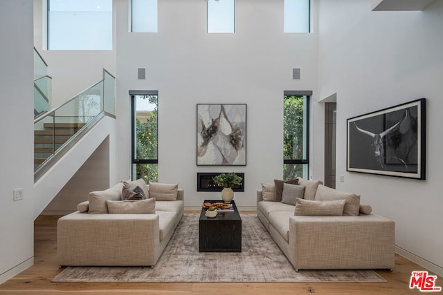 living room with hardwood / wood-style floors and a towering ceiling