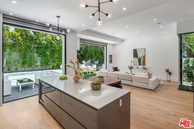 kitchen with a notable chandelier, a spacious island, decorative light fixtures, and light wood-type flooring