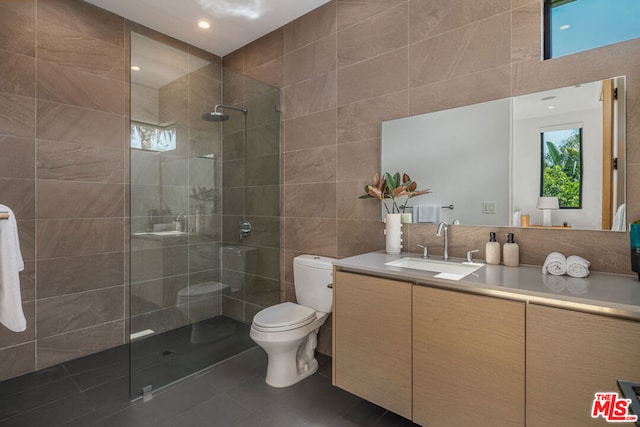 bathroom featuring tile patterned flooring, vanity, tile walls, and toilet