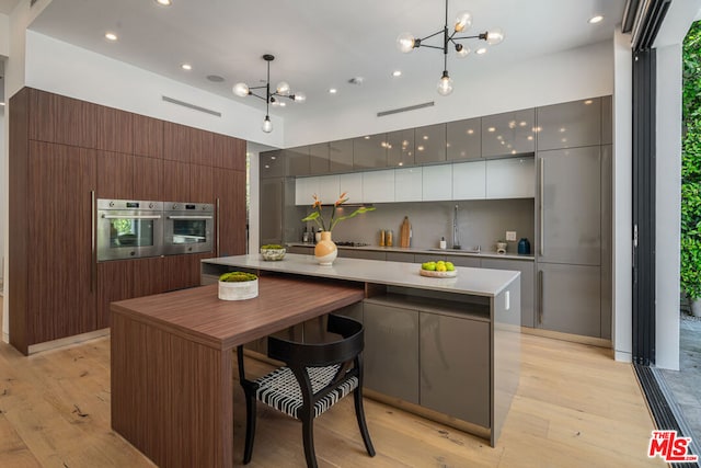 kitchen with oven, a center island, and hanging light fixtures