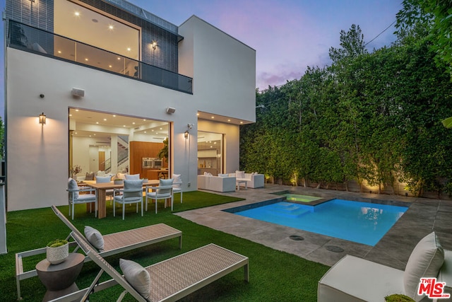 pool at dusk with an in ground hot tub, a yard, an outdoor living space, and a patio area