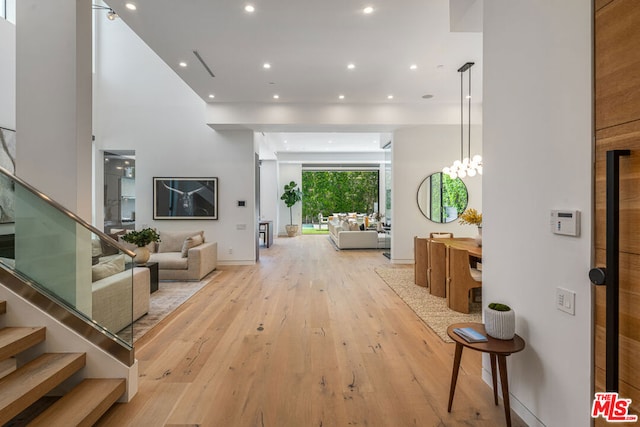 hall with light hardwood / wood-style flooring and a chandelier