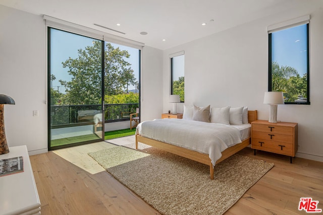 bedroom with access to outside and light hardwood / wood-style floors