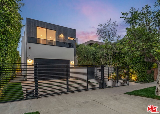 contemporary house featuring a garage and a balcony