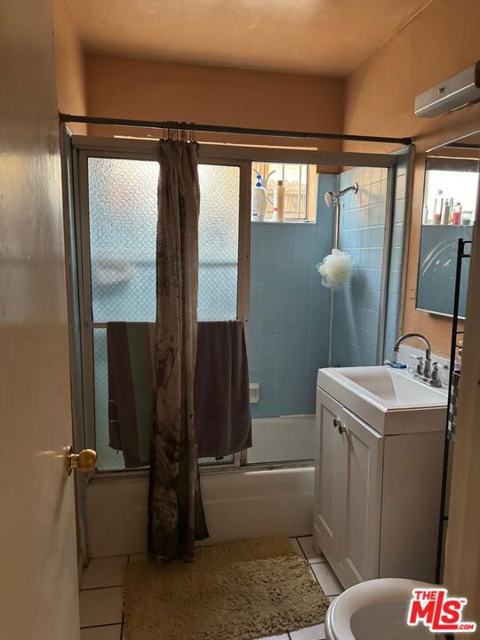 full bathroom featuring shower / tub combo, vanity, toilet, and tile patterned floors