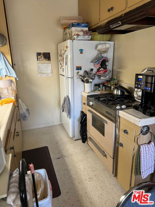 kitchen featuring tile counters and white gas range