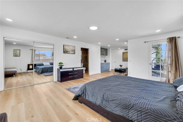 bedroom with light wood-type flooring, a closet, and access to outside