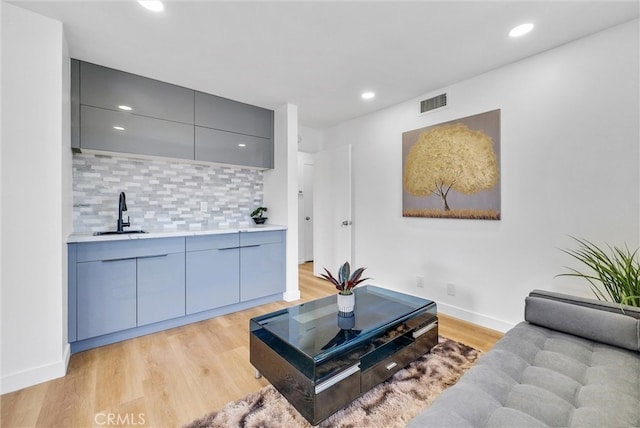 living room with light hardwood / wood-style floors and sink