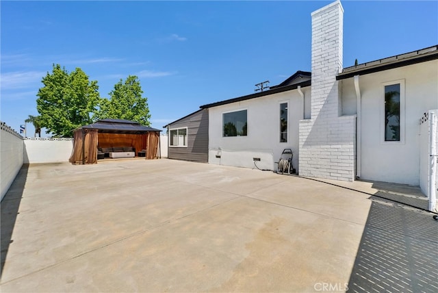 view of patio / terrace featuring a gazebo and a hot tub