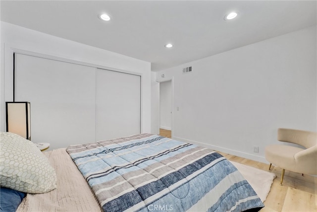 bedroom with light wood-type flooring and a closet