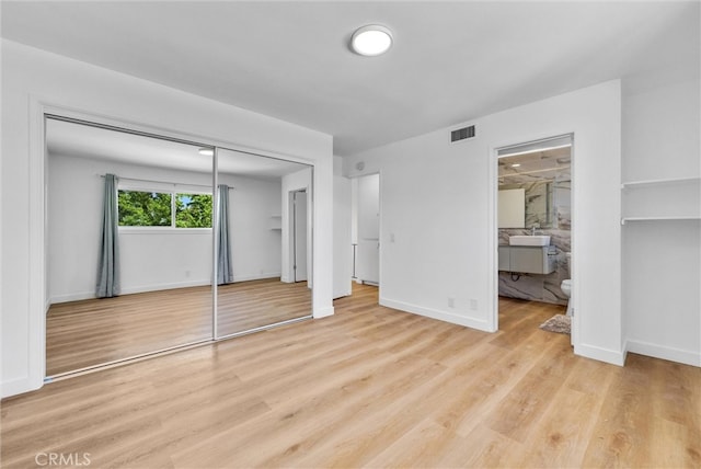 unfurnished bedroom featuring light hardwood / wood-style flooring and ensuite bathroom