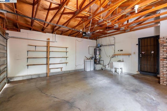 garage with strapped water heater, a garage door opener, and sink