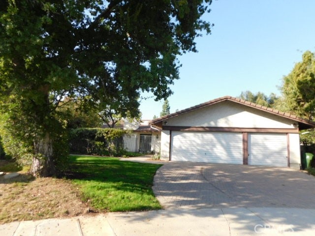 ranch-style house featuring a front yard and a garage