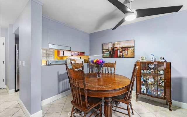 tiled dining area featuring ceiling fan and ornamental molding