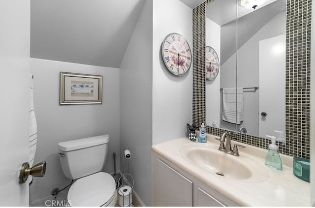 bathroom featuring lofted ceiling, vanity, and toilet