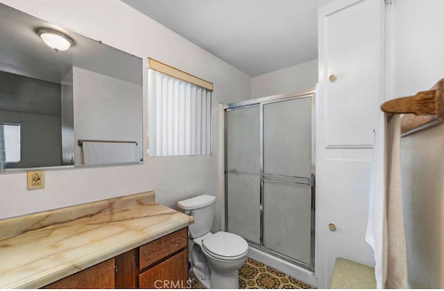 bathroom with a shower with door, toilet, and vanity