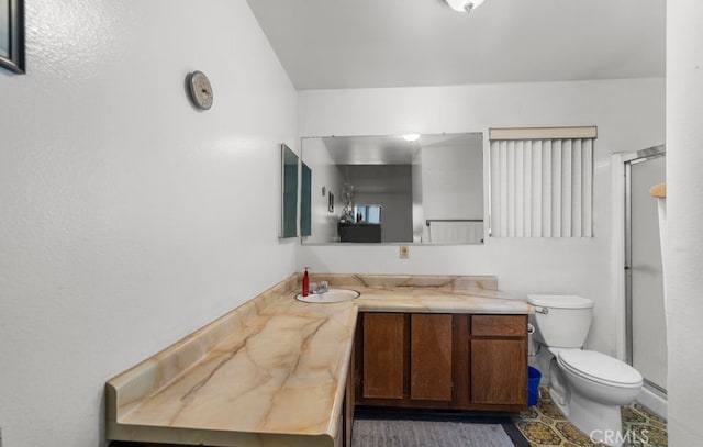 bathroom with vanity, toilet, tile patterned floors, and a shower with shower door