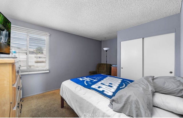 carpeted bedroom featuring a textured ceiling and a closet