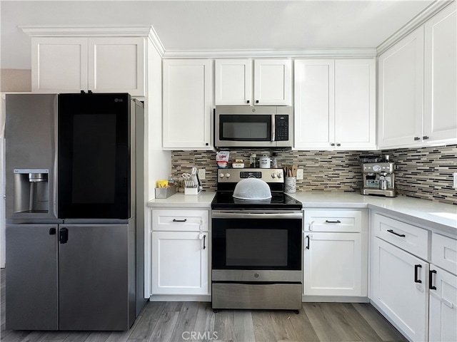 kitchen with white cabinets, appliances with stainless steel finishes, and light wood-type flooring