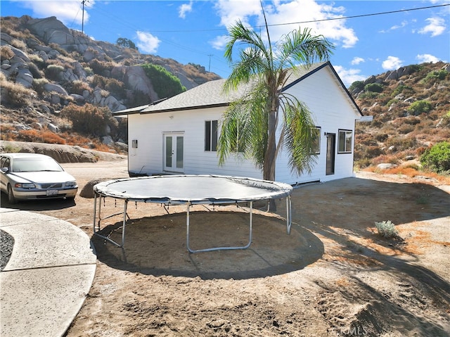 view of home's exterior with a trampoline and a mountain view