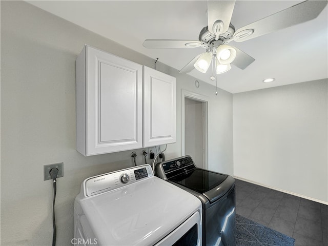 laundry room with washing machine and dryer, ceiling fan, dark tile patterned floors, and cabinets