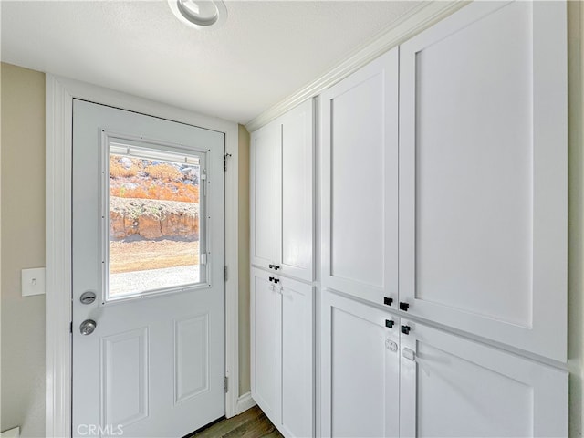 doorway to outside with a textured ceiling and dark hardwood / wood-style flooring