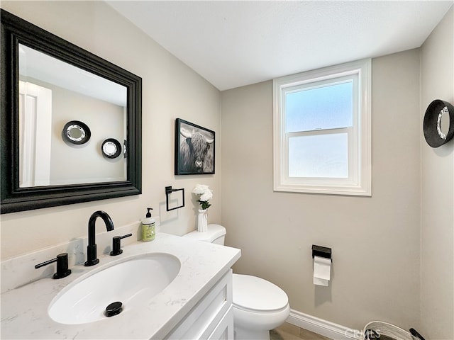 bathroom with vanity, toilet, and a textured ceiling