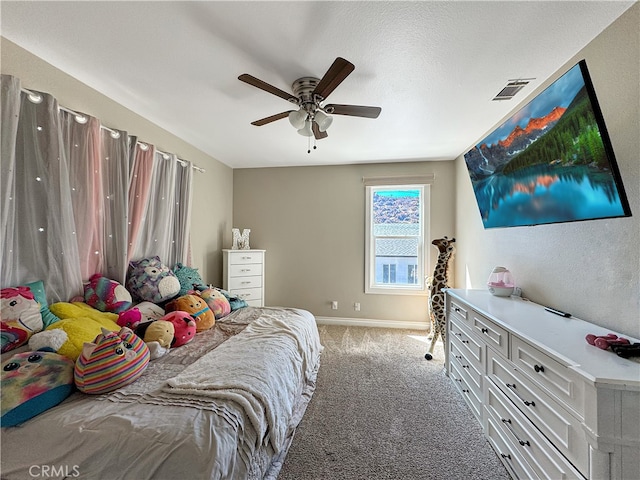 carpeted bedroom with ceiling fan and a textured ceiling