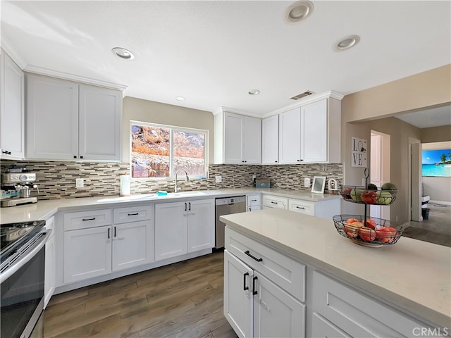 kitchen featuring sink, appliances with stainless steel finishes, dark wood-type flooring, and white cabinetry