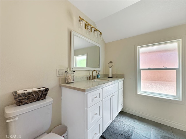 bathroom featuring tile patterned floors, lofted ceiling, vanity, and toilet