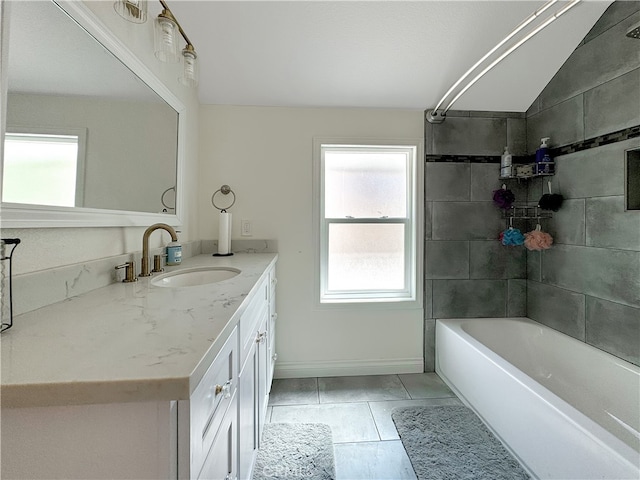 bathroom with lofted ceiling, vanity, tile patterned floors, and tiled shower / bath