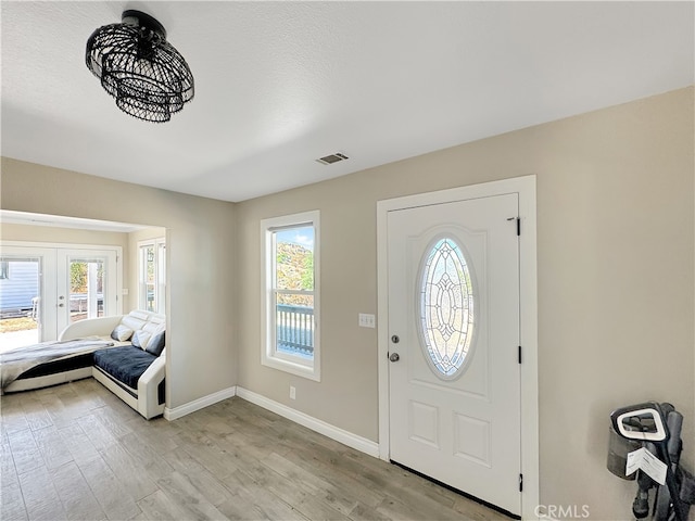 entrance foyer featuring a textured ceiling, light hardwood / wood-style flooring, and plenty of natural light