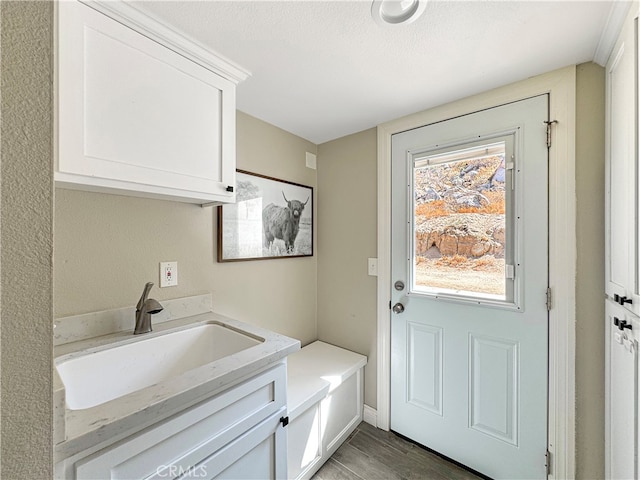 interior space featuring a textured ceiling, sink, and light hardwood / wood-style flooring