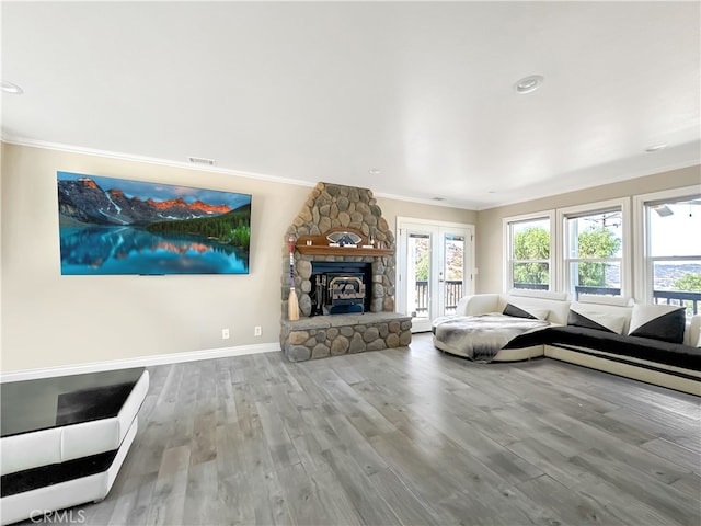 unfurnished living room with ornamental molding, light hardwood / wood-style floors, and a stone fireplace