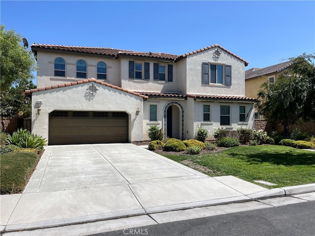 mediterranean / spanish-style house with a garage and a front yard