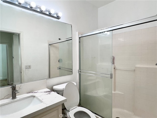 bathroom featuring walk in shower, vanity, and toilet