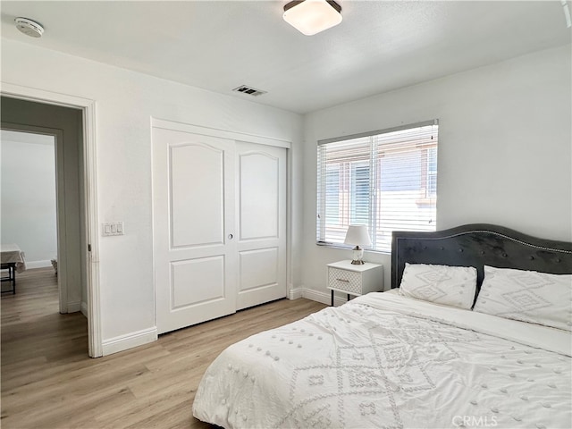 bedroom with light hardwood / wood-style flooring and a closet