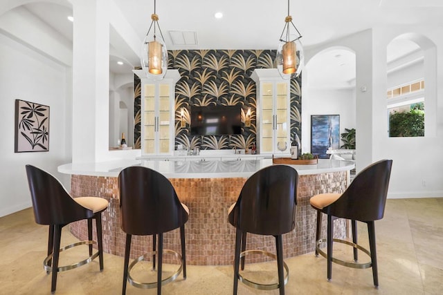 bar with light tile patterned flooring and decorative light fixtures