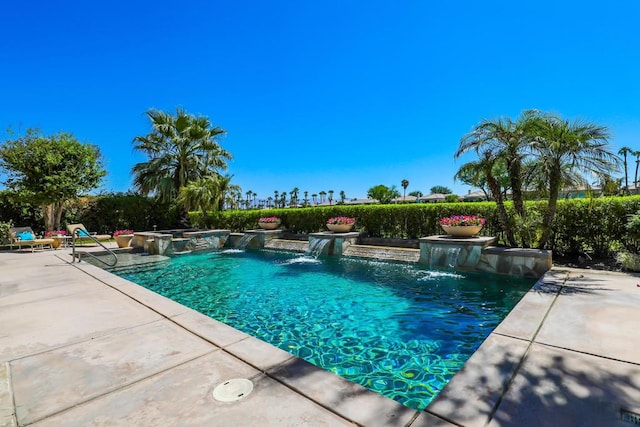 view of swimming pool with pool water feature, a patio, and a jacuzzi