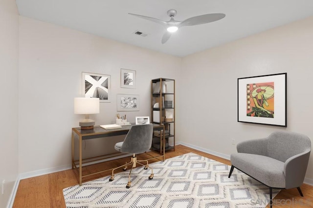 office with light wood-type flooring and ceiling fan