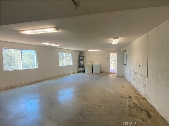 basement featuring electric panel, washer and clothes dryer, and water heater