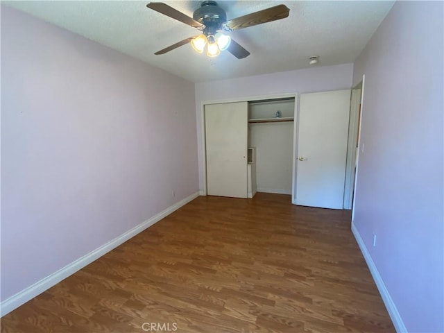 unfurnished bedroom with hardwood / wood-style floors, ceiling fan, and a closet